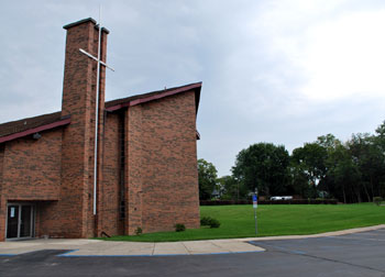 church in background showing van accessible sign and marking leading to ramp; accessibility illustration