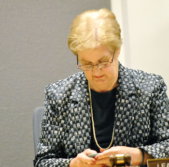 DDA board chair Leah Gunn checks her smart phone before the start of the Nov. 7 meeting.