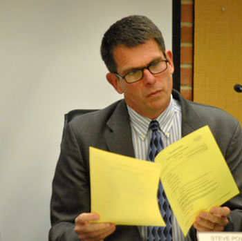 Ann Arbor city administrator Steve Powers peruses the printed copy of the council's agenda.