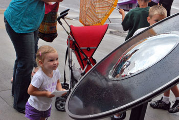 A youngster plays music on the phonograph made by Michael Flynn.