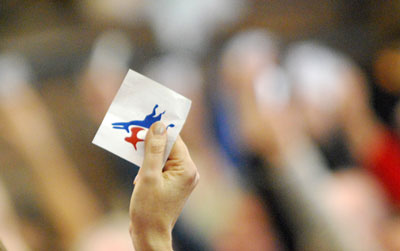 Attendees held their credential aloft to vote.