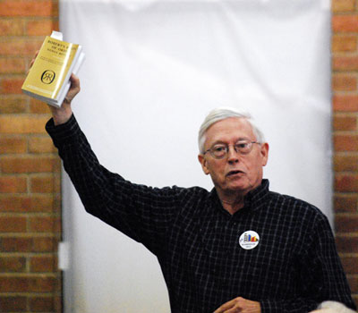 David Cahill held aloft a copy of Robert's Rules of Order.