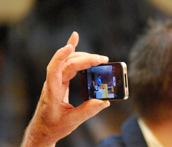 The proceedings were documented by several people in the audience using smartphones.