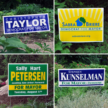Campaign yard signs for candidates in the Ann Arbor Democratic mayoral primary.