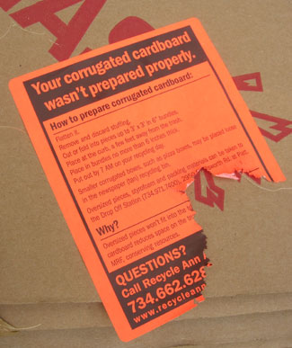 The stickers left by recycling truck personnel on non-conforming cardboard bundles are not exactly like this one. They leave whole stickers.  By the time the Chronicle was able to document this sticker, however, it had been detached and re-attached again. 
