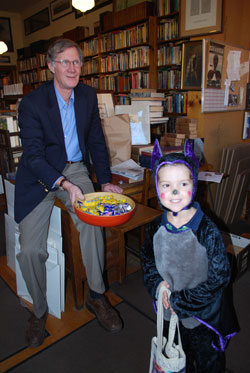 Doug Price passes out candy to a BatGirl at the West Side Book Shop. Just out of frame is the store's proprietor, Jay Platt, and customer (and long-time local fundraising giant) Joe Fitzsimmons, who came by to drop off a book.