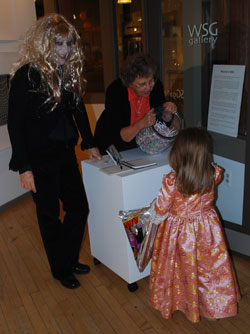 Nora Venturelli and Jean Lau, partners with WSG Gallery on Main Street, give out DumDums to a princess.