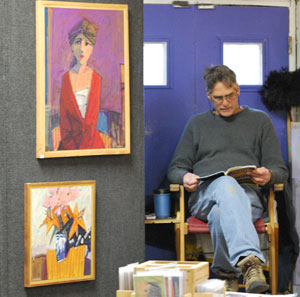 Local artist Jim Lounsbury next to some of his oil paintings.