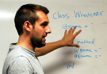 guy teaching programming class at white board