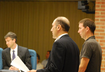 Two men stand together at a podium at the Ann Arbor city council