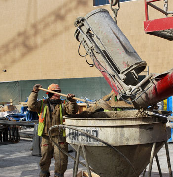 Construction worker fills bucket with gravel