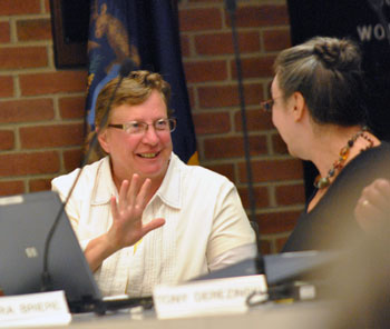 Left to right: Sandi Smith (Ward 1) tells Sabra Briere (Ward 1) how many minutes Jane Lumm had been speaking – five. Council members are supposed to be limited to two speaking turns on any given question, the first of which has a limit of five minutes and the second three minutes.